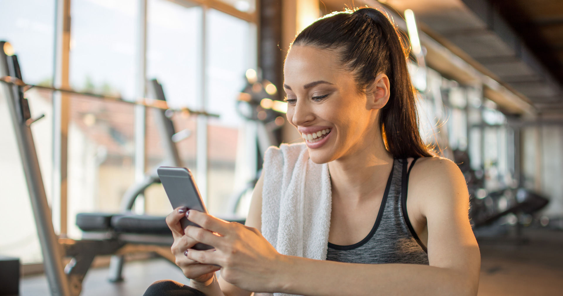 Fitnessstudiomitglied am Handy im Fitnessstudio