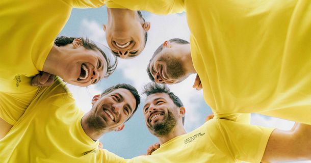 Menschen mit gelben T-Shirts umarmen sich 