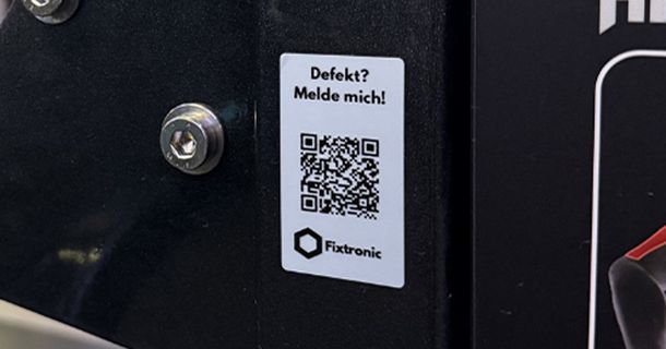 Fitnessgerät auf dem ein QR-Code mit der Aufschrift Defekt? Dann melde dich angebracht ist