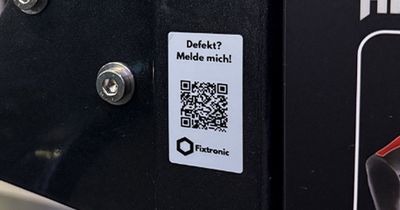 Fitnessgerät auf dem ein QR-Code mit der Aufschrift Defekt? Dann melde dich angebracht ist