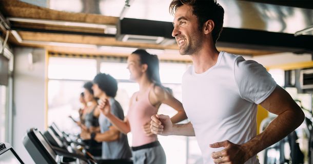 Fröhliche Sportler auf Laufbändern im Gym