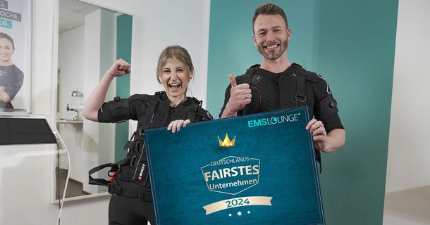Mann und Frau im EMS-Anzug und Urkunde in der Hand freuen sich über die Auszeichnung