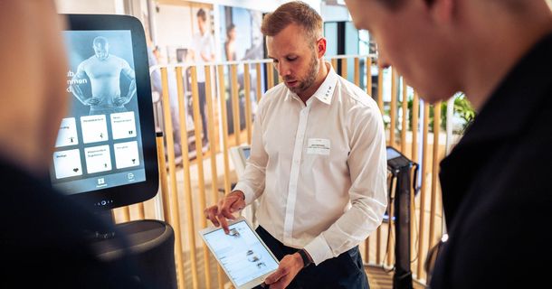 EGYM-Mitarbeiter erklärt Interessenten Auswertungeb am Tablet