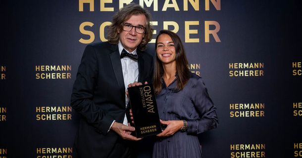 Hermann Scherer, Veranstalter des Speaker Slam, überreicht Vanessa Buth den Excellence Award