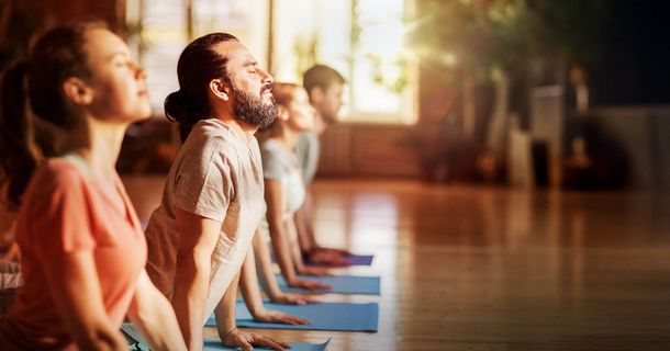 Fitnessstudiomitglieder beim Yoga im Fitnesskurs