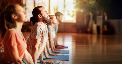 Fitnessstudiomitglieder beim Yoga im Fitnesskurs