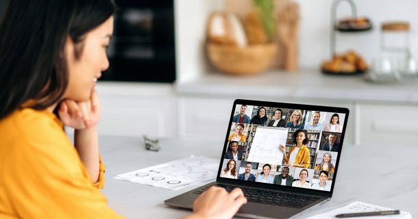 Frau mit dunklen Haaren vor Laptop im Meeting
