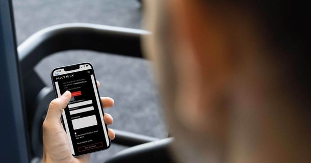Mann im Fitnessstudio hat auf dem Smartphone die SERVICE DIRECT App von MAtrix geöffnet