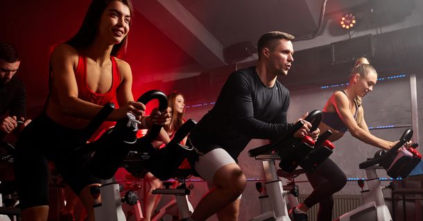 Spinning Class, Indoor Cycling in einem rot erleuchetenKursraum