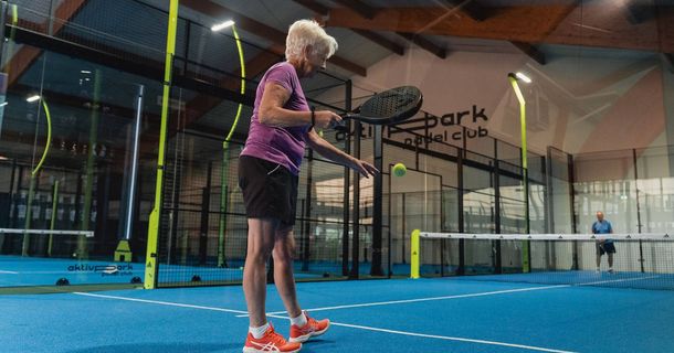 Ältere Dame beim Aufschlag auf einem Padelplatz