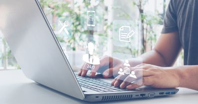 Mann sitzt vor Laptop am Schreibtisch