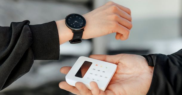 Frau bezahlt mit ihrer Polar-Uhr an einem Kartenlesegerät