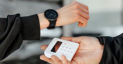 Frau bezahlt mit ihrer Polar-Uhr an einem Kartenlesegerät