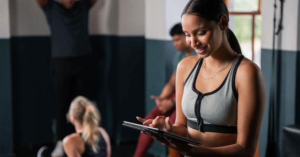 Trainerin mit Tablet im Gym