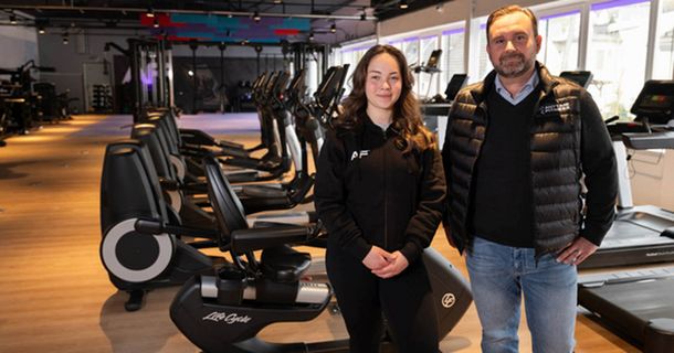 Betreiber eines Anytime Fitness Studios posieren vor ihren Geräten