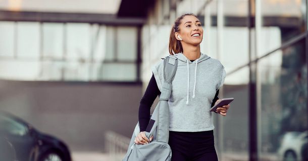 Frau läuft zum Fitnesstraining mit Sporttasche