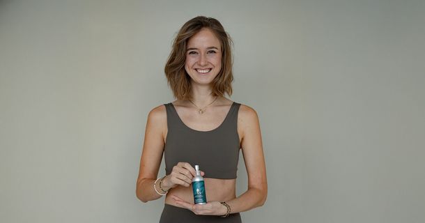 Junge Frau präsentiert das INSUI Active Care Body Spray