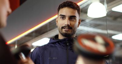 Trainer schaut auf mit Hanteln Trainierenden im verschwommenen Vordergrund