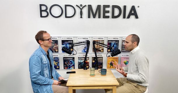 Nico Hessel sitzt im Interview mit Constantin Wilser von BODYMEDIA an einem Tisch mit zwei Mikrofone.  
