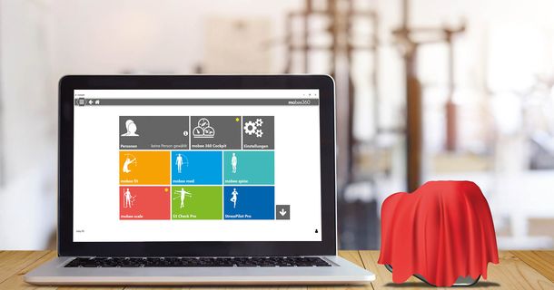 Laptop mit mobee Software, daneben die neue Hardware, verdeckt mit einem roten Tuch