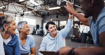 Eine Gruppe älterer Frauen im Fitnessstudio mit einem Fitnesstrainer