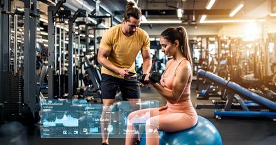Frau trainiert mit einem Trainer ihre Arme, im Vordergrund Fitnessdaten