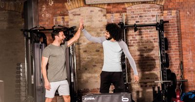 Zwei Männer im Trainingsoutfit und -umgebung machen High Five