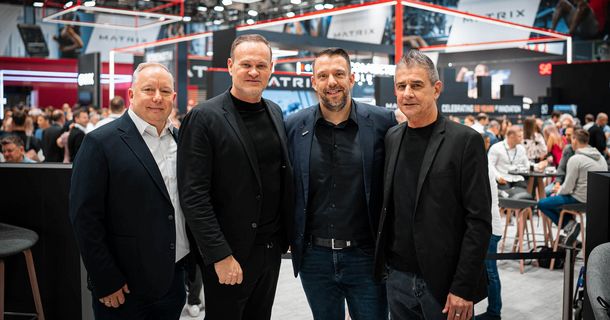 Ulfert Böhme und Markus Rau von Matrix stehen mit Michael Mäder von EASYFITNESS auf der FIBO und feiern ihre Zusammenarbeit