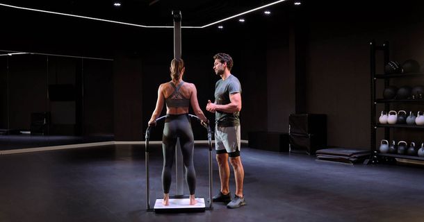 Junge Frau macht Messung auf der seca TRU, Trainer steht daneben