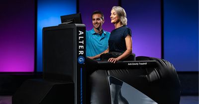 Frau auf AlterG NEO während Trainer erklärt