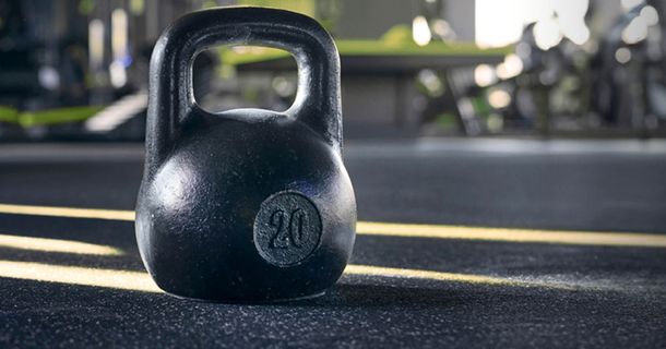 Schwarze Kettlebell auf schwarzem Sportboden im Fitnessstudio