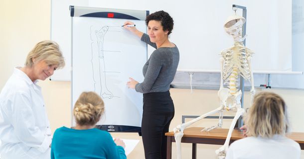 Lehrerin unterrichtet Gesundheitsanbieter in den Themen Bewegung, Prävention, Rehabilitation und Trainingslehre