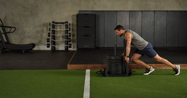 Man schiebt Gewichte beim HYRTOX-Training