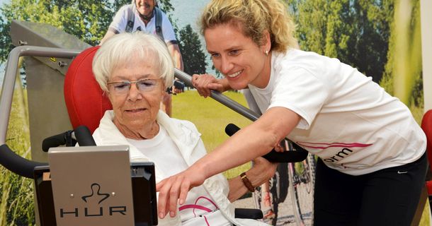 Trainerin erklärt Seniorin den Umgang mit den HUR-Geräten