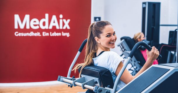 Frau trainiert an einem Gerät im MedAix