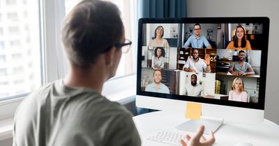 Mann von hinten vor Laptop im Meeting