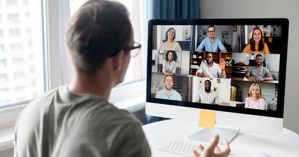 Mann von hinten vor Laptop im Meeting