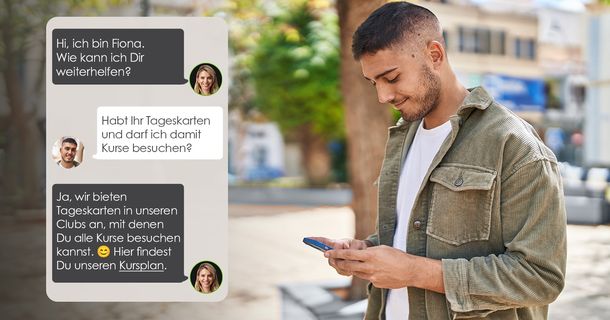 Fitnessstudiomitglied lächelt in die Kamera. SIe steht vor einer Steinwand und tippt etwas in ihr Handy