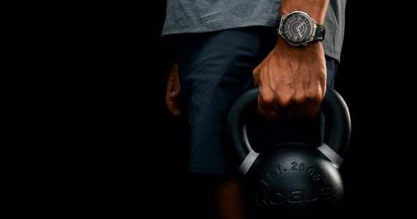 Männerhand hält Kettle Bell, eine Smartwatch von Amazfit am Handgelenk