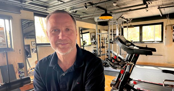 Roy Kühne der Physiotherapeut sitzt lächelnd in einem Home Gym