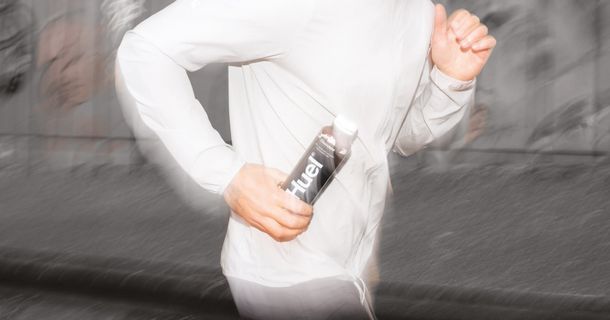 Jogger mit Huel Trinkmahlzeit in der Hand