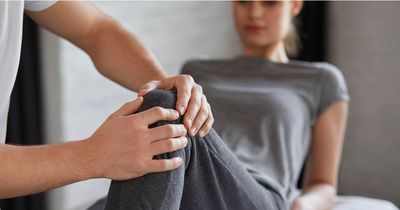 Physiotherapeut behandelt Frau am Knie