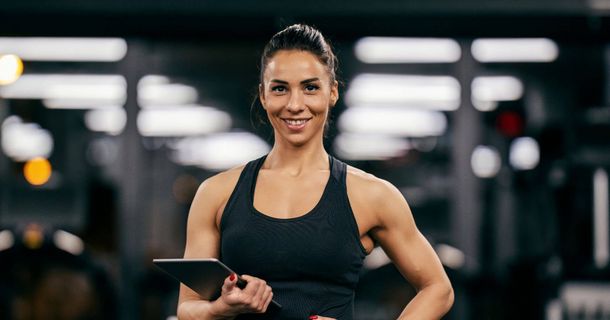 Sportliche Frau mit Tablet im Fitnessstudio