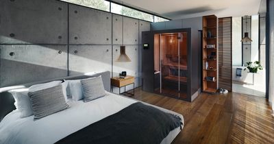 Schickes Zimmer, mit Bett im Vordergrund und KLAFS-Sauna im Hintergrund