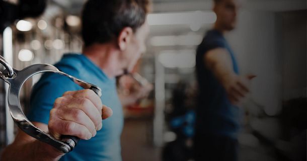 Älterer Sportler an Kabelzugmaschine