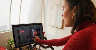 Frau auf Peloton-Bike schaut auf den Bildschirm 