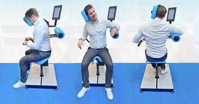 Junger Mann im Anzug  trainiert seinen Nacken am HUR Nackentrainer