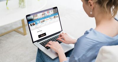Junge Frau sitzt vor dem Laptop und tippt