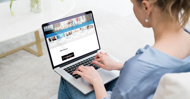 Junge Frau sitzt vor dem Laptop und tippt
