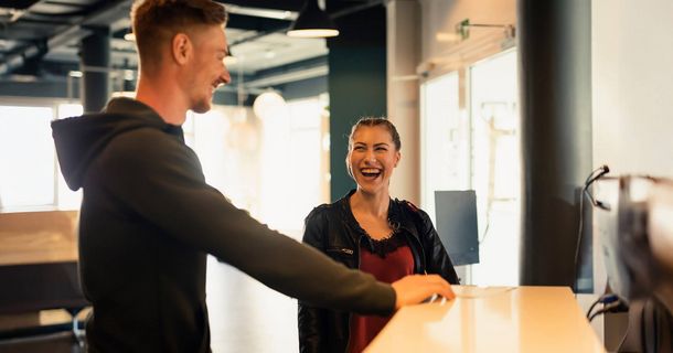 Trainer und Fitnessstudiomitglied an der Theke